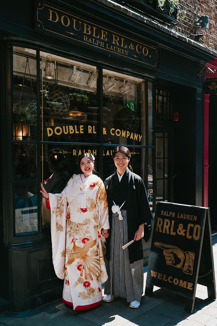 A couple in traditional Japanese wedding attire standing outside Double RL & Co store entrance.