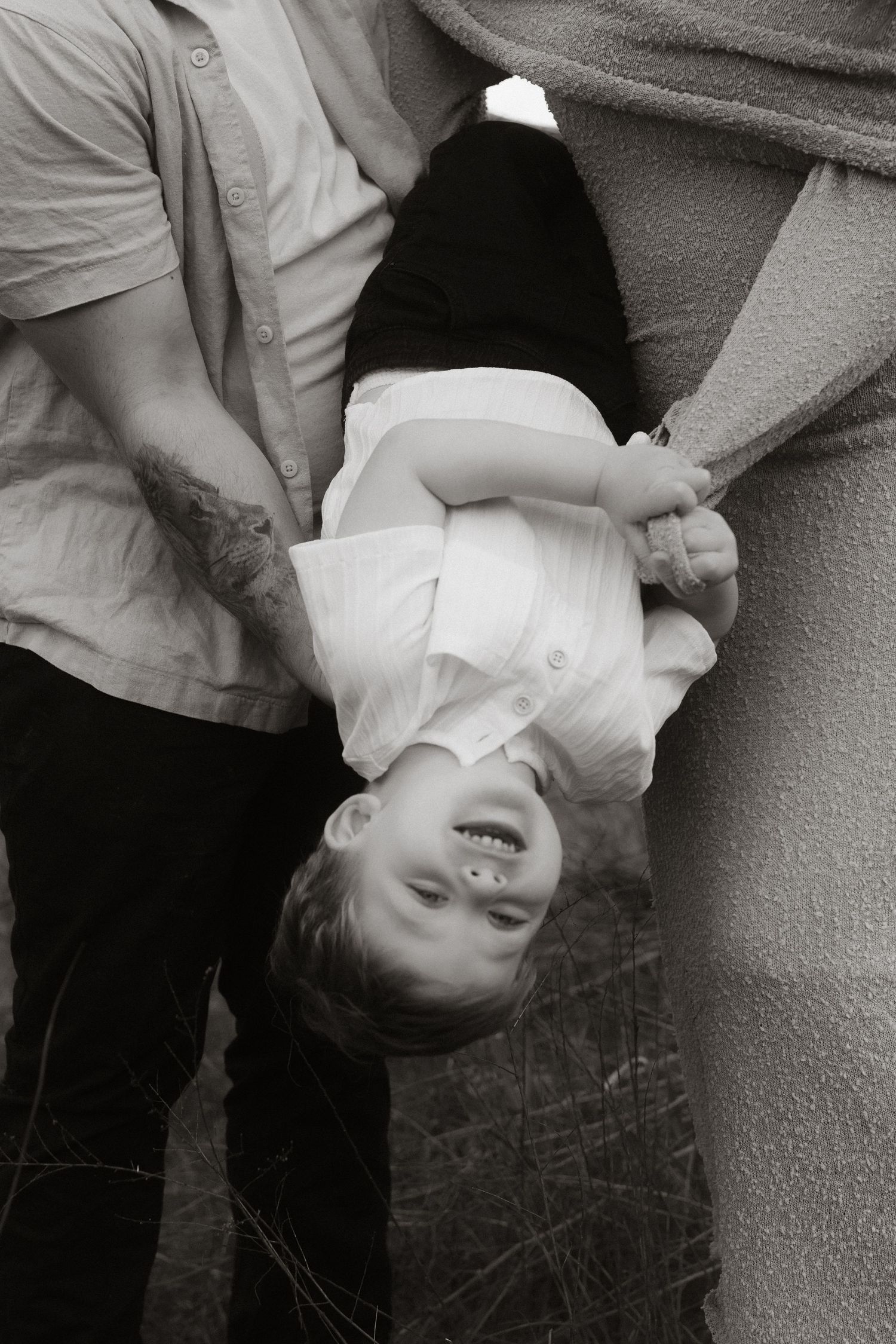 Playful family moment captured in black and white photography.