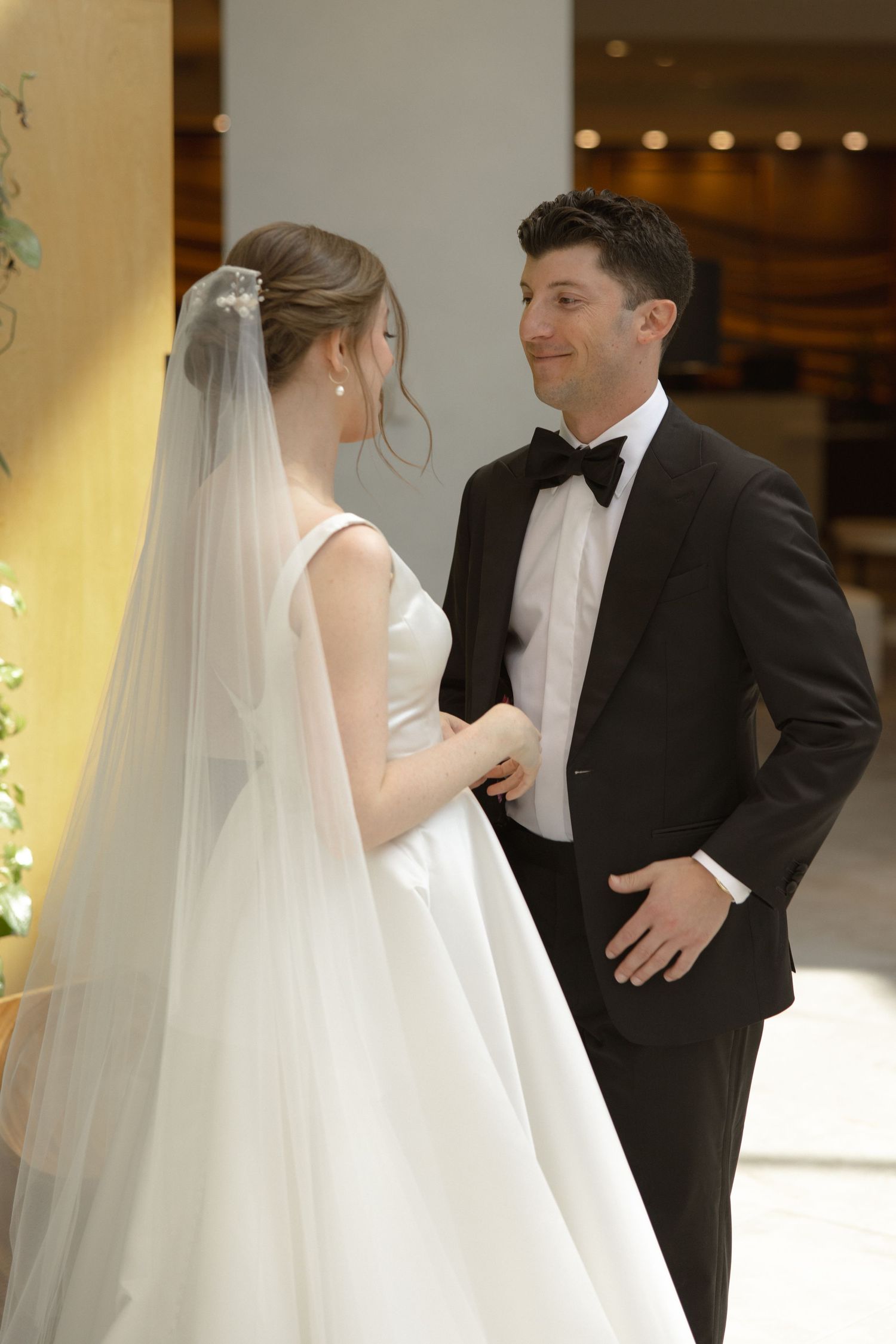 A tender moment between newlyweds, with the bride in a classic white gown and the groom in a black tuxedo.