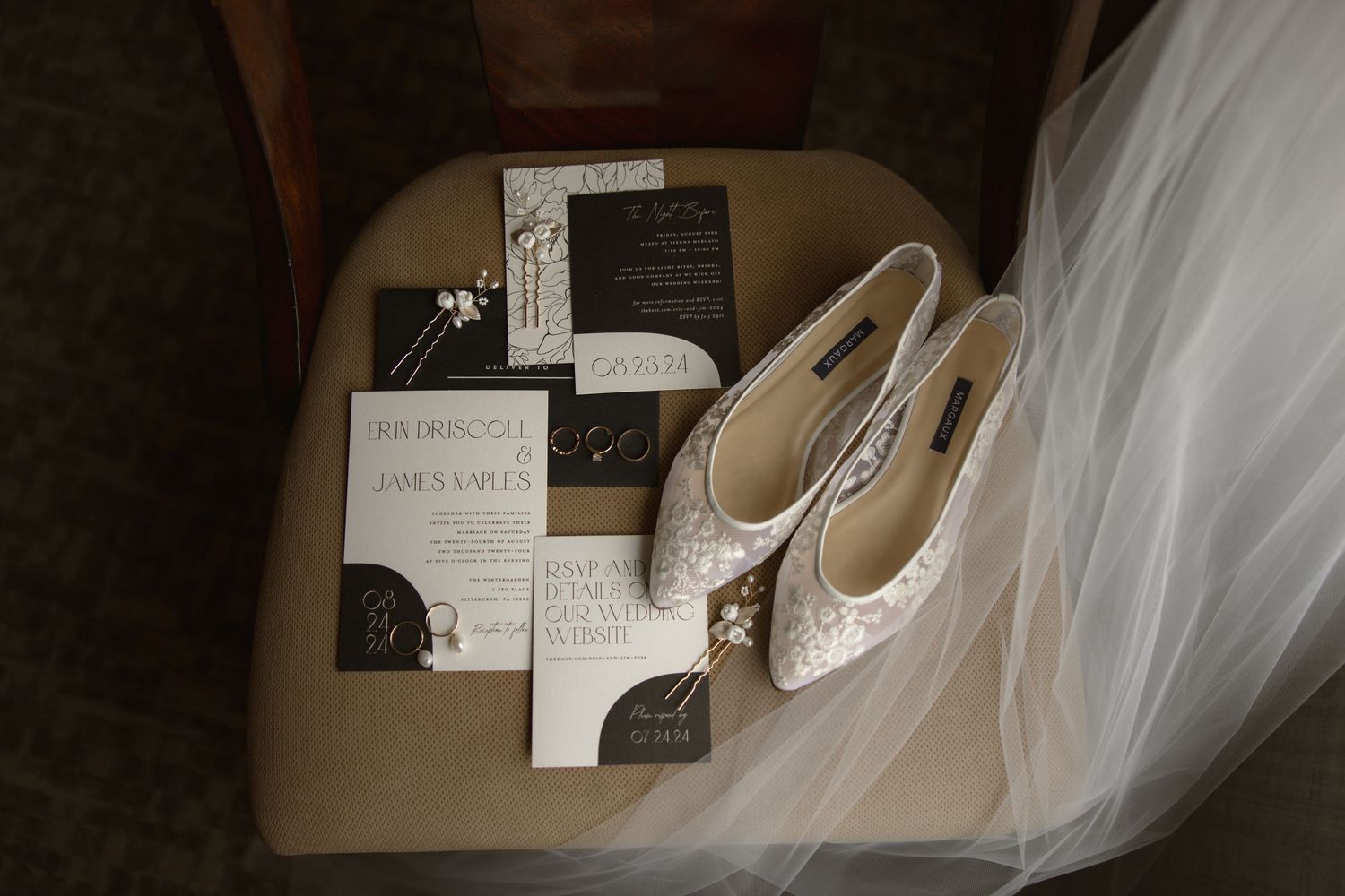 Wedding details flatlay with lace shoes, invitations and white tulle veil on beige chair.