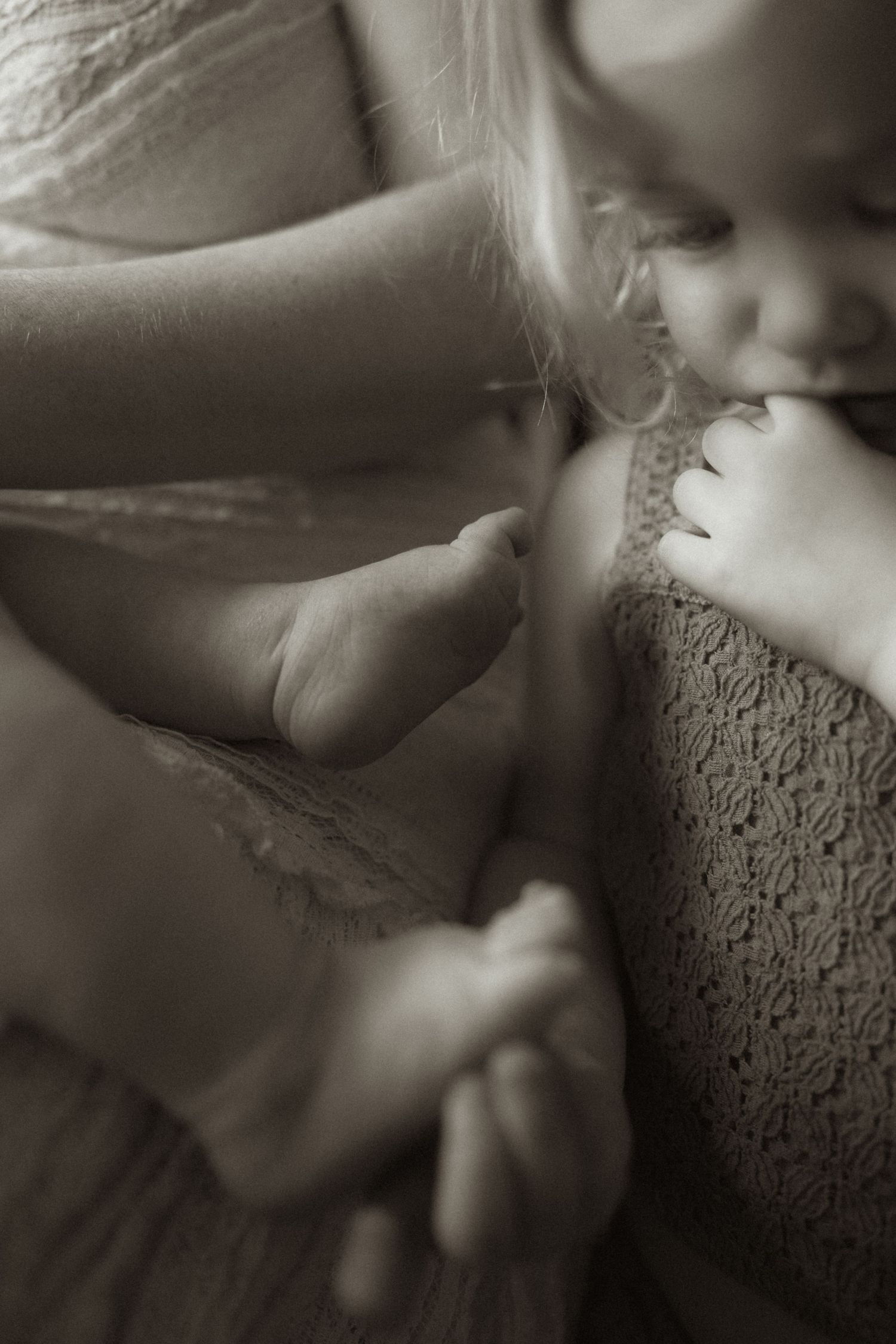 A series of sepia-toned close-up photographs showing delicate hand gestures against a textured fabric background.