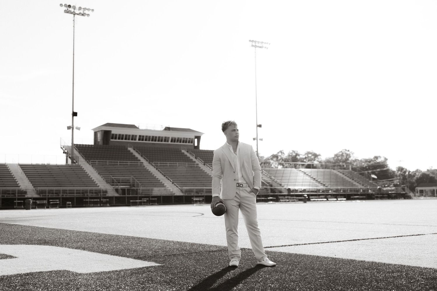 A figure in white stands in an empty football stadium in this vintage black and white photograph.