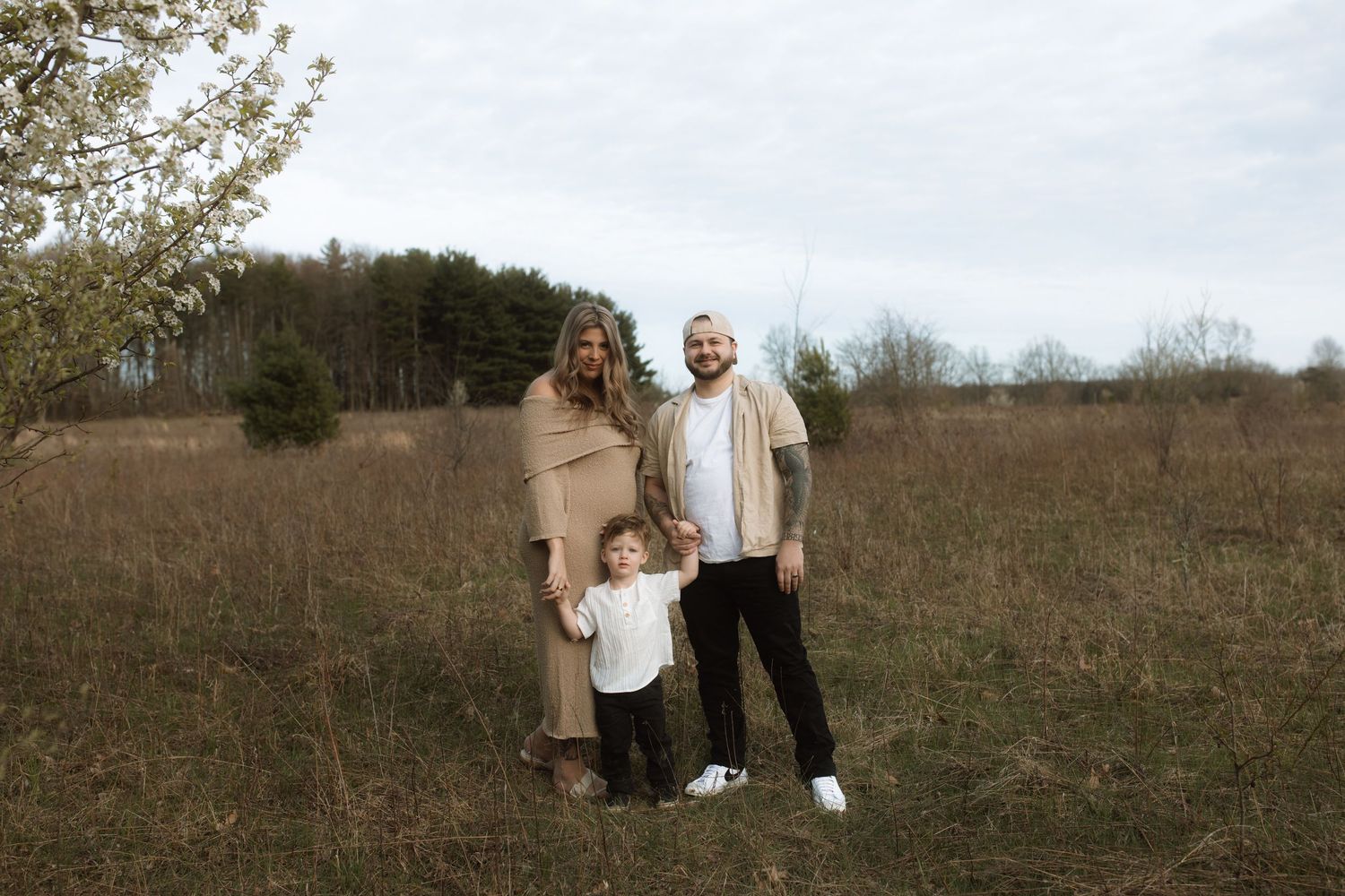 A family photo session in a rustic field during early spring.