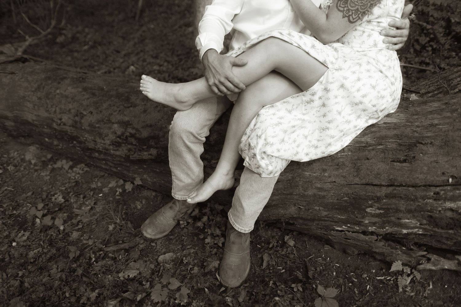 Black and white vintage photo showing bare legs and feet in shoes contrasting with a polka dot dress.