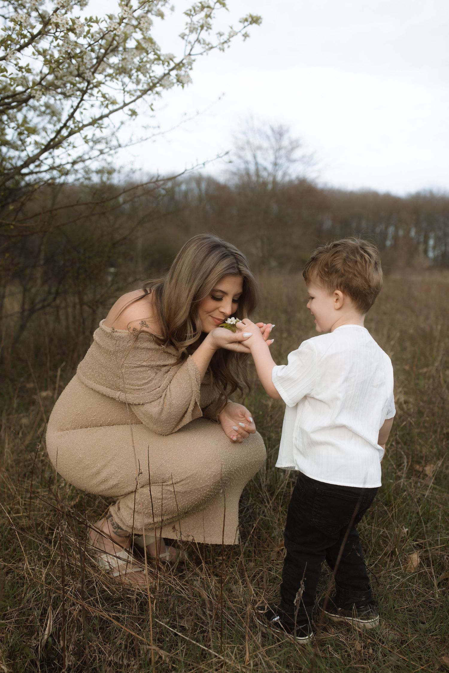 A sweet moment captured in a field as a child shares flowers.