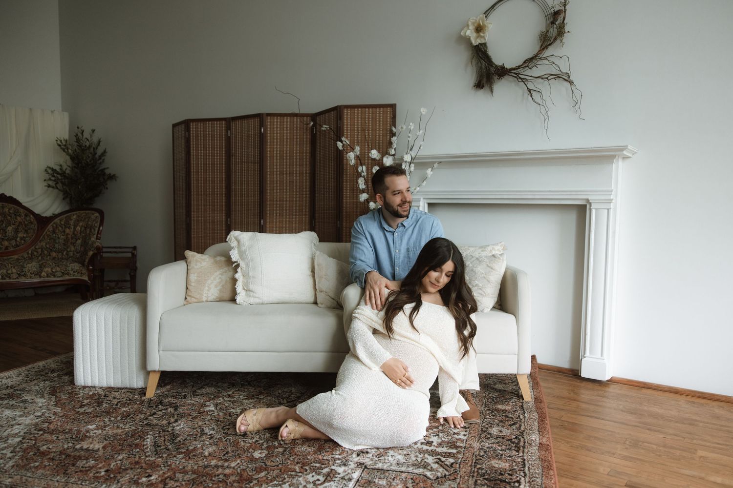 A vintage-style boudoir photography shoot showing intimate poses against a minimalist white wall and furniture setting.