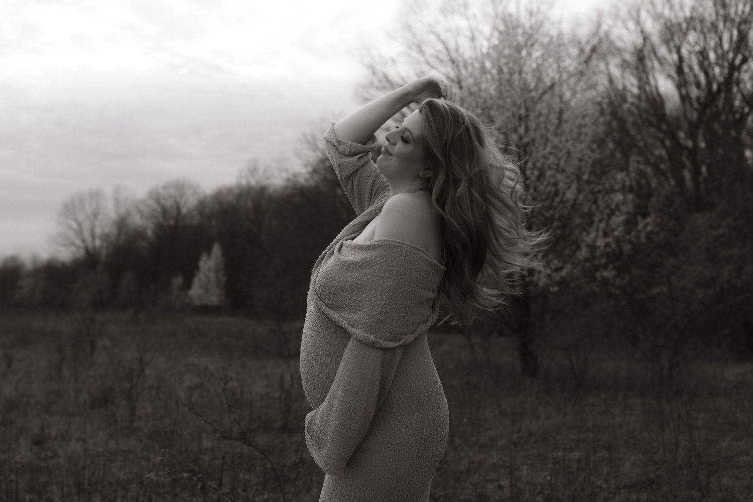 Side view silhouette of pregnant woman outdoors in black and white.
