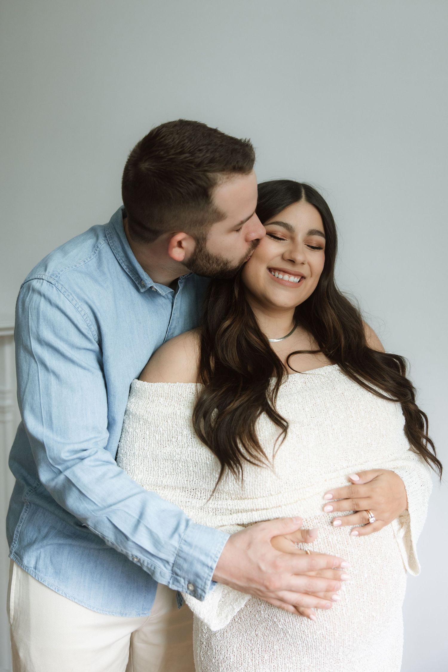 A couple shares tender moments in a sequence of six intimate maternity photos against a light gray background.