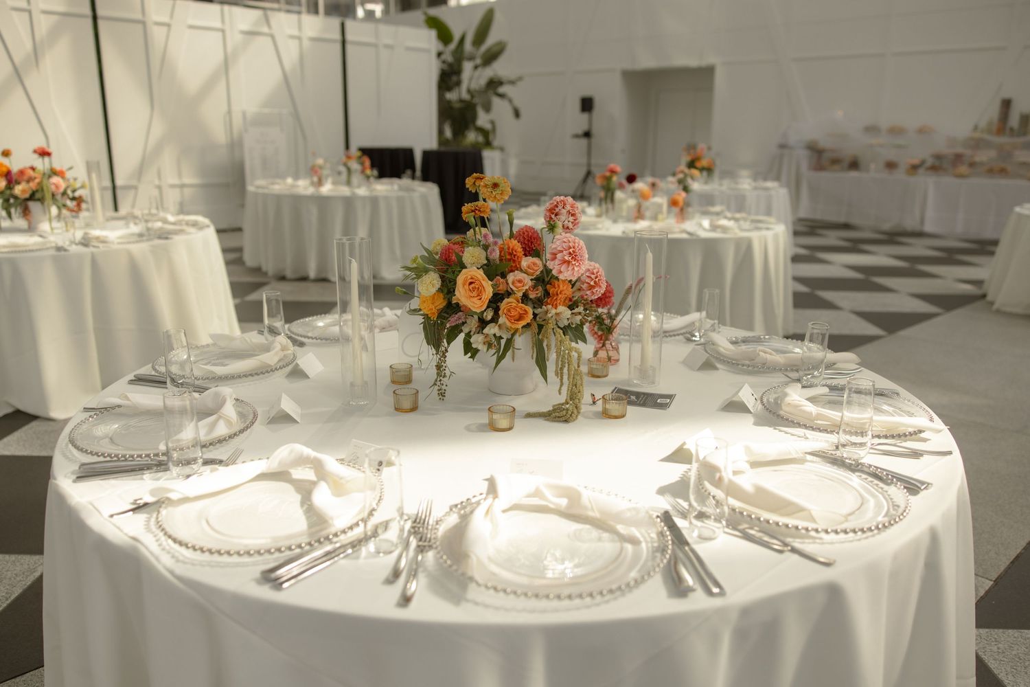 Elegant table setting with floral centerpiece and crystal glassware at wedding reception.