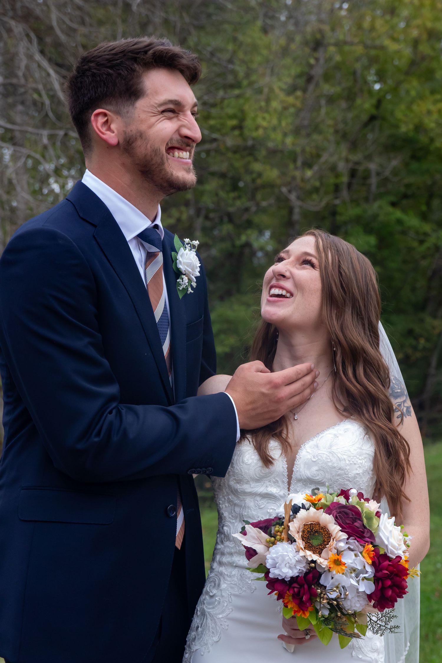Joyful wedding moment captured outdoors with colorful autumn bouquet.