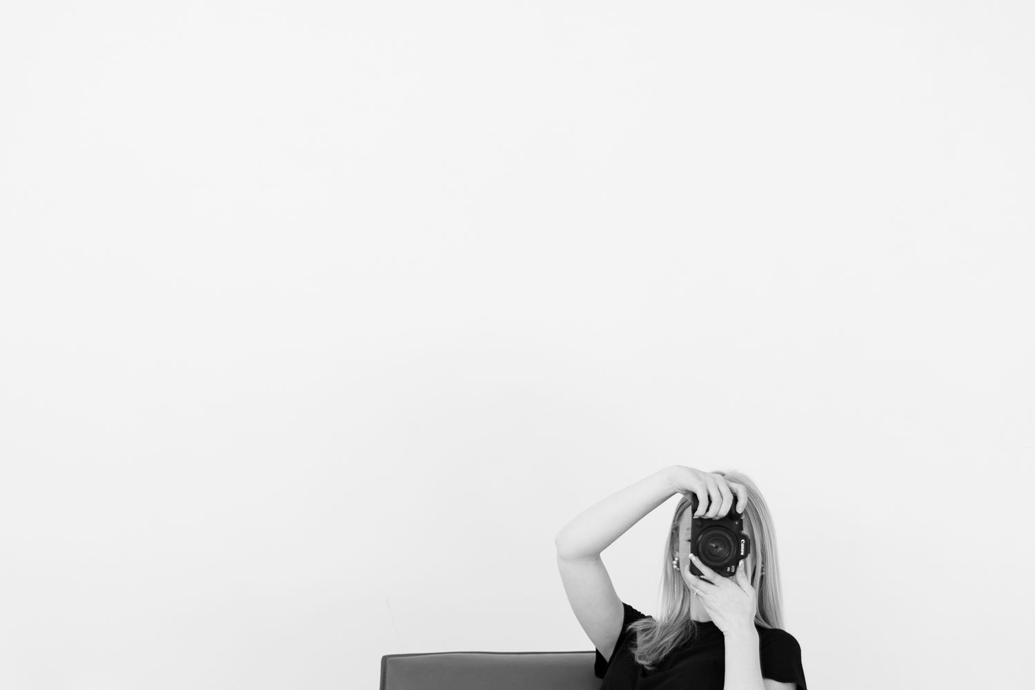 Black and white photo of person laying down while taking pictures.