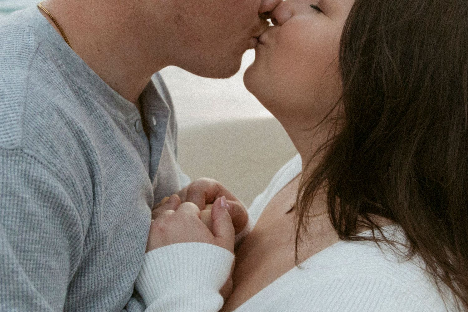 Tender close-up moment between couple in casual winter wear.