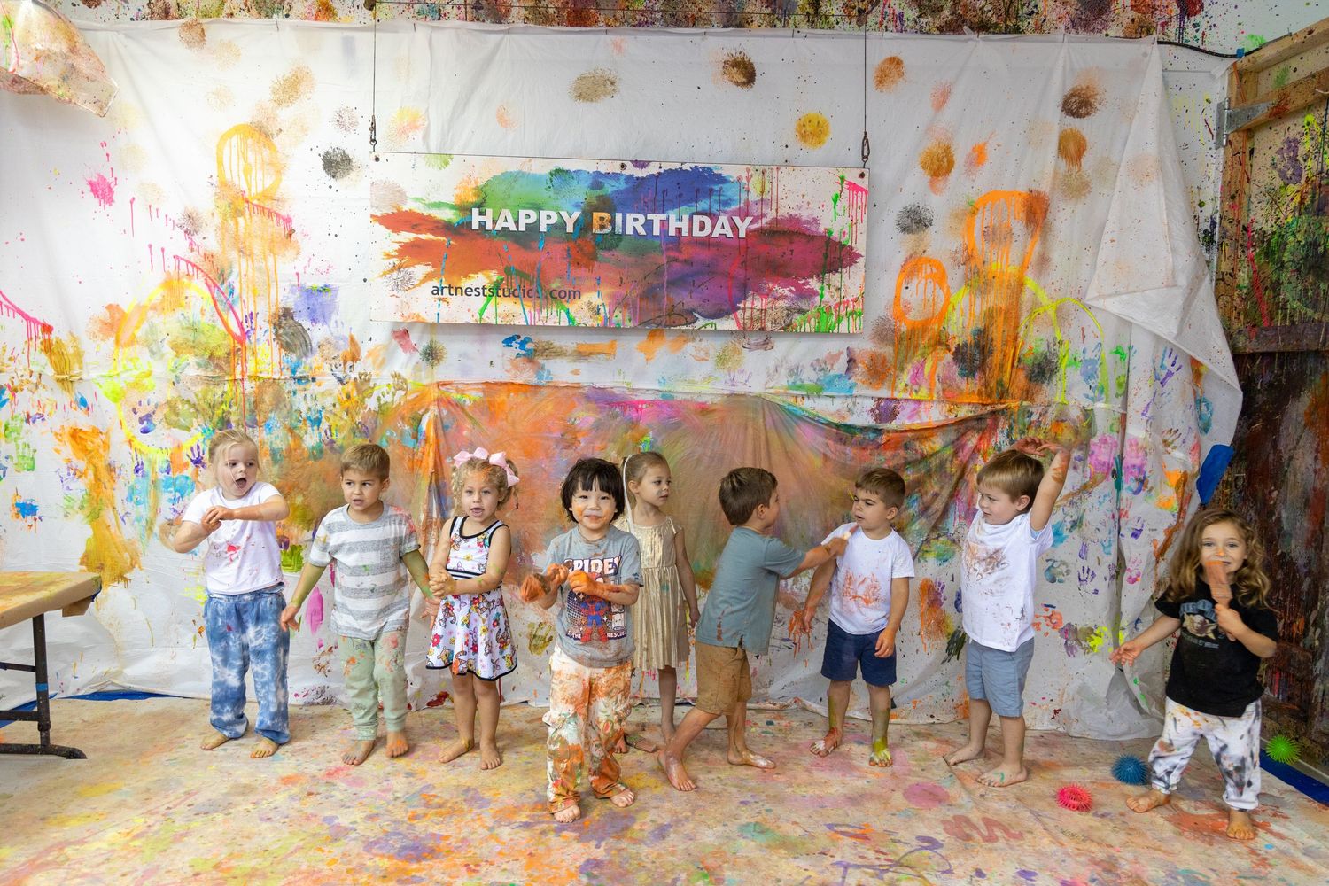 Paint-splattered birthday party celebration with colorful decorations and banners.