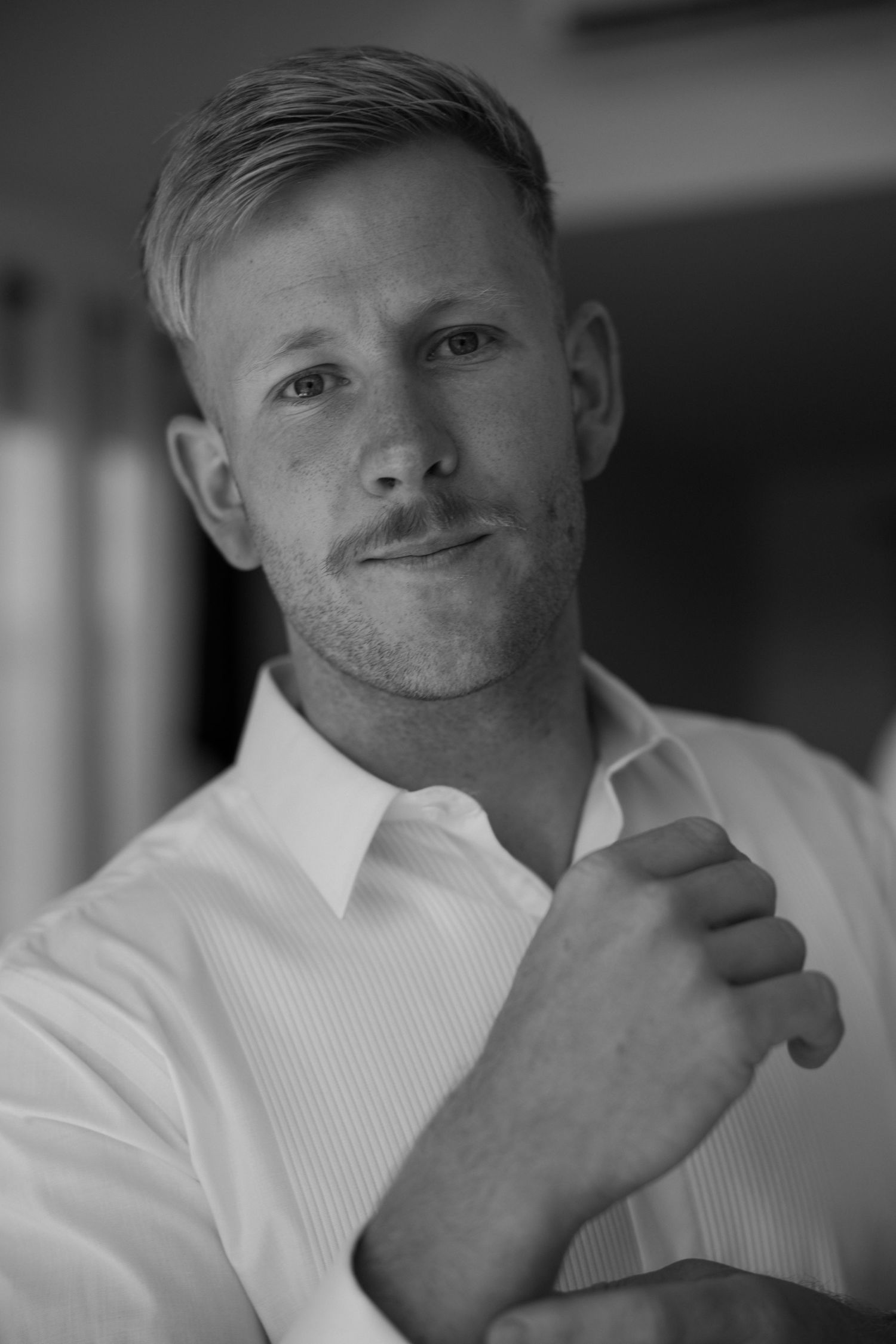 A black and white portrait of a person in a white dress shirt.