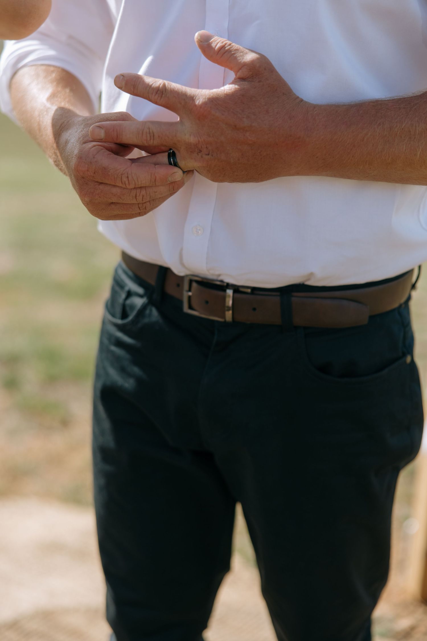 Close-up of hands adjusting a ring during wedding ceremony.