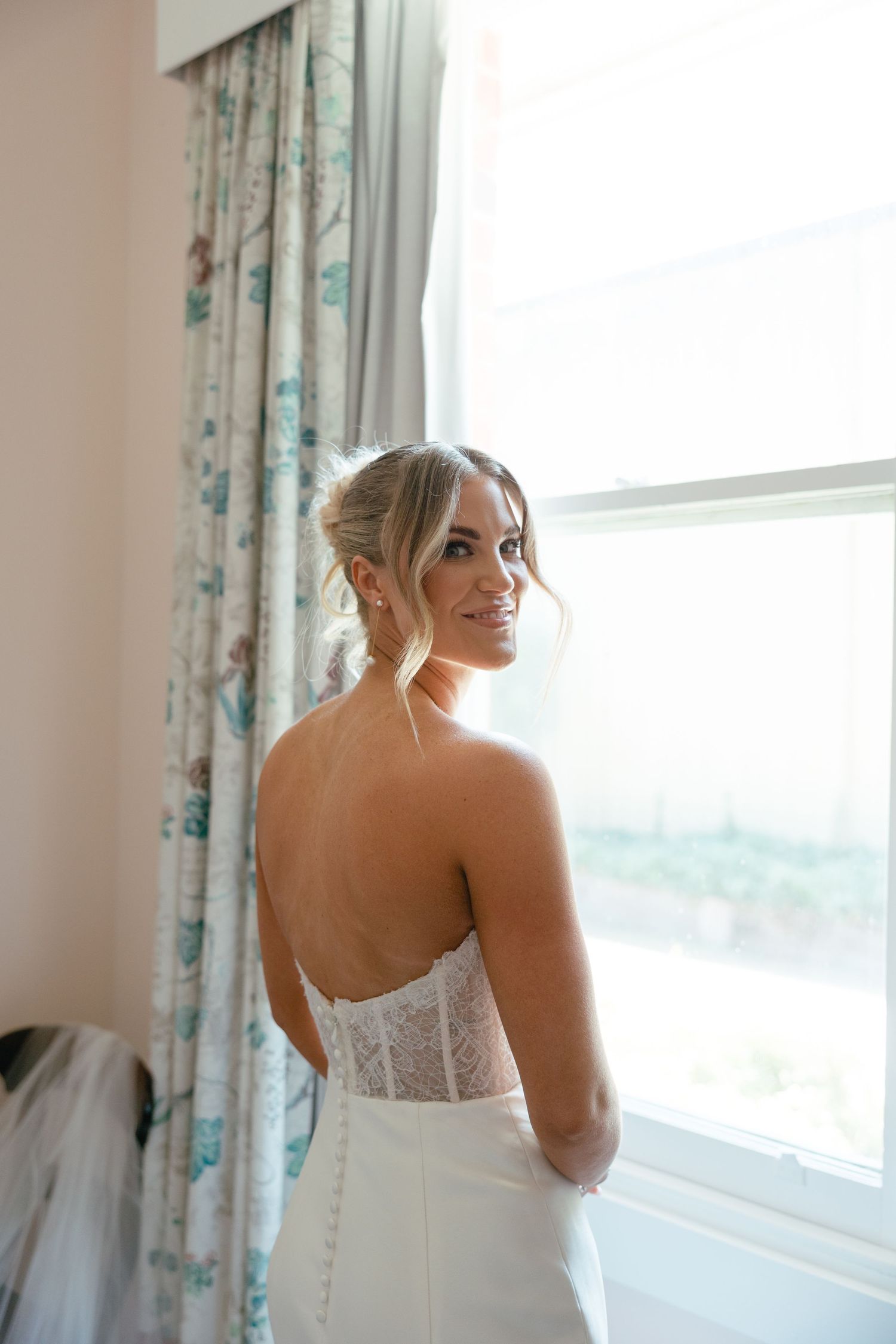 Elegant bridal portrait showing the back detail of a strapless wedding gown.