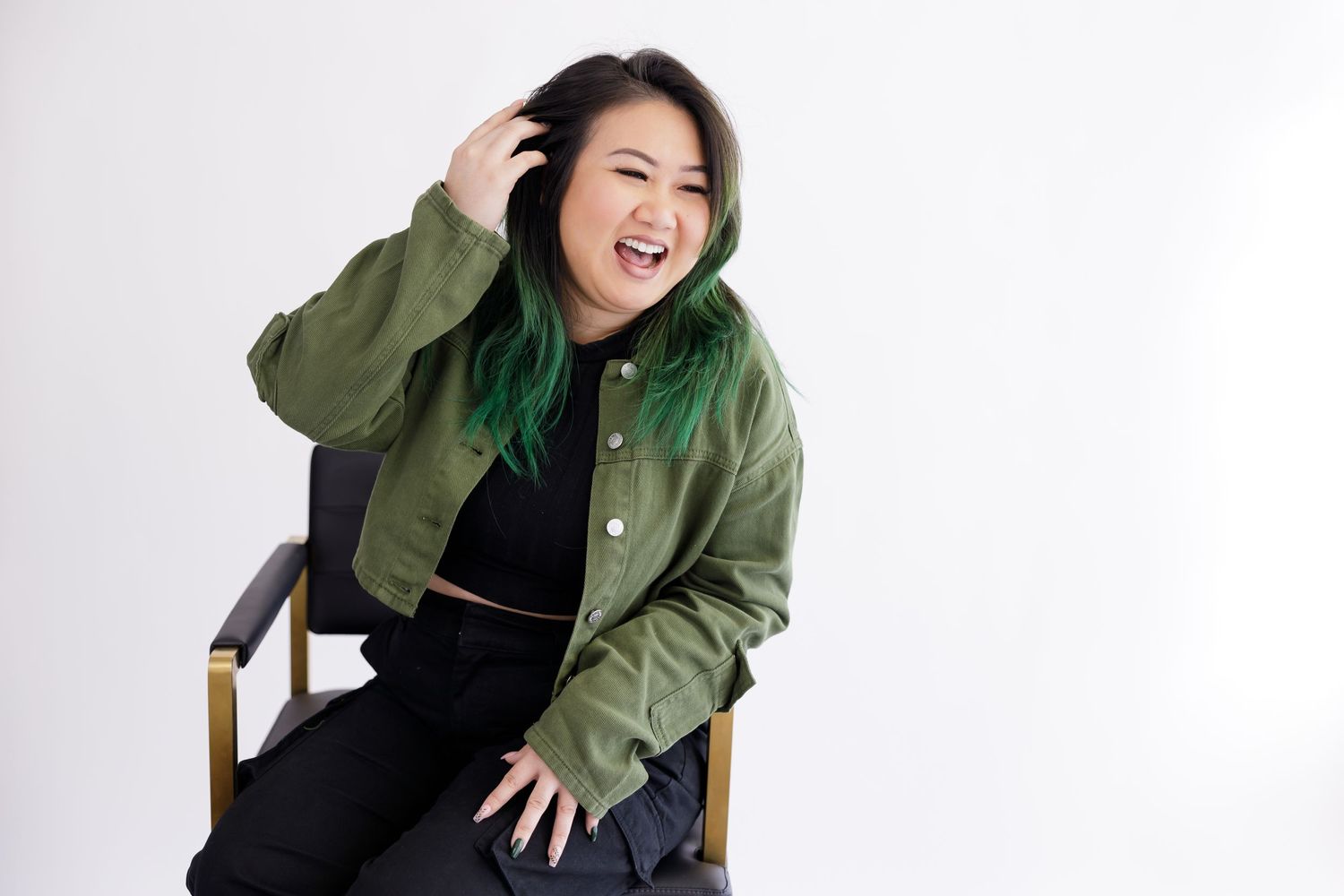woman hair stylist in maple valley, WA business owner for fun headshot, sitting running hands through hair laughing Maple Valley, WA