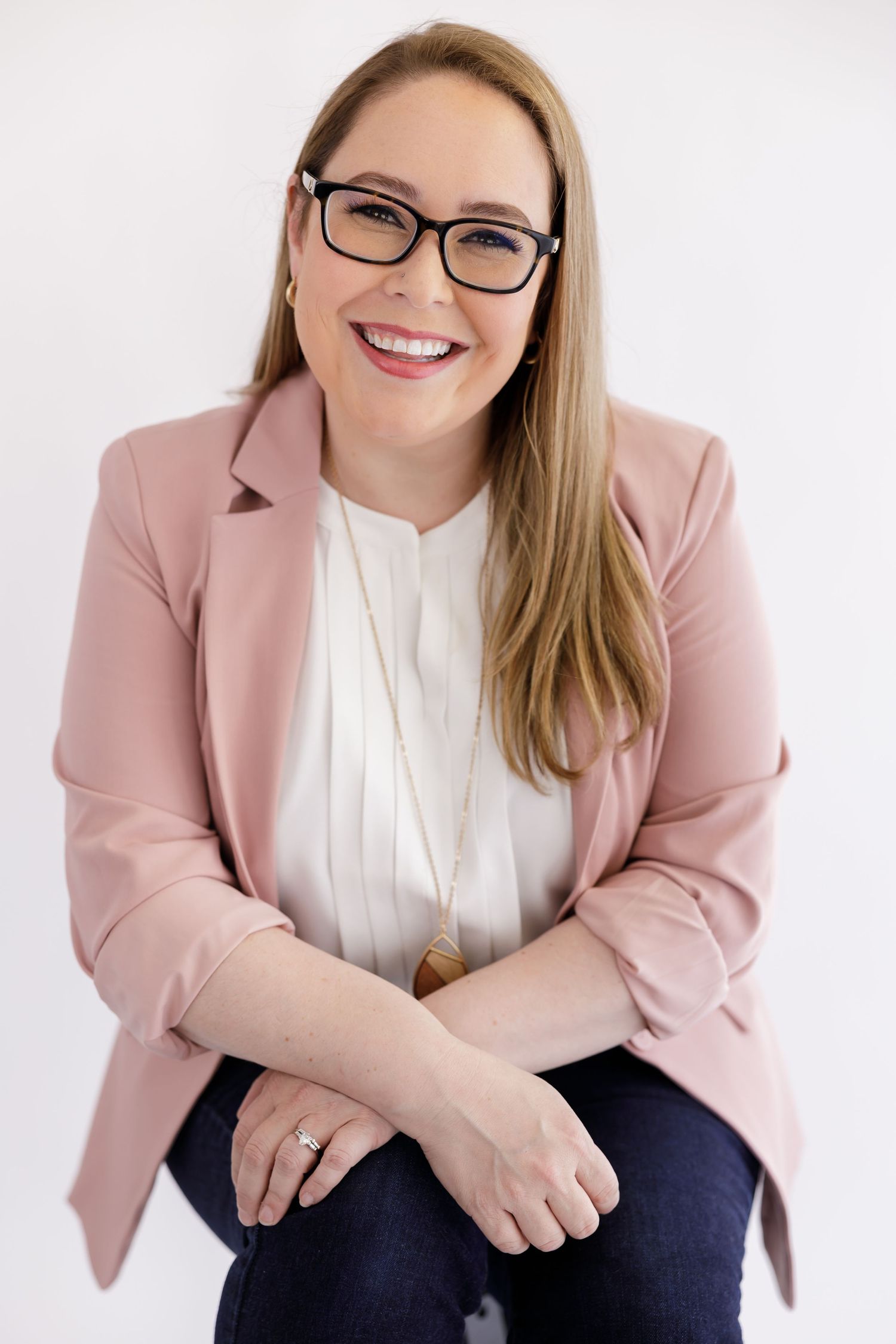 woman business owner coach headshot sitting smiling in pink blazer and white blouse in Bothell, WA