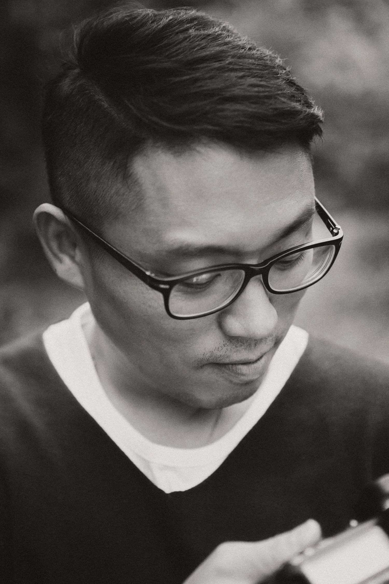Close-up portrait showing thoughtful expression while reading in monochrome.
