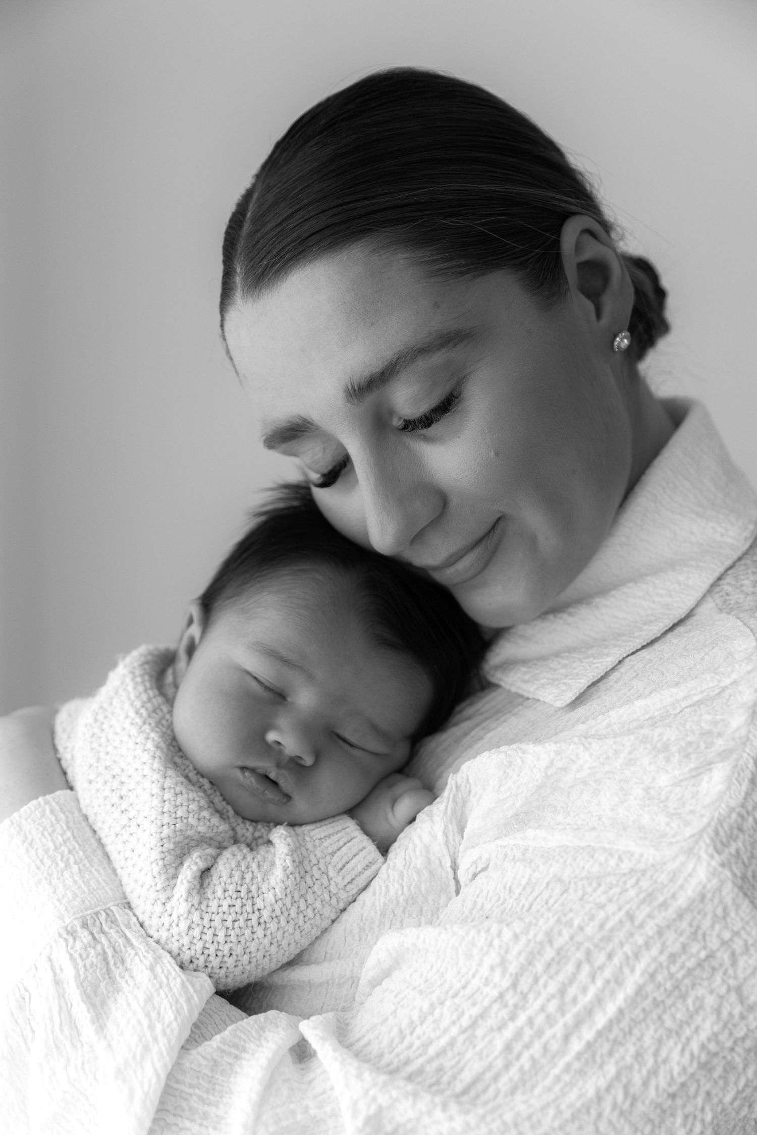 Intimate black and white portrait of tender newborn moment.