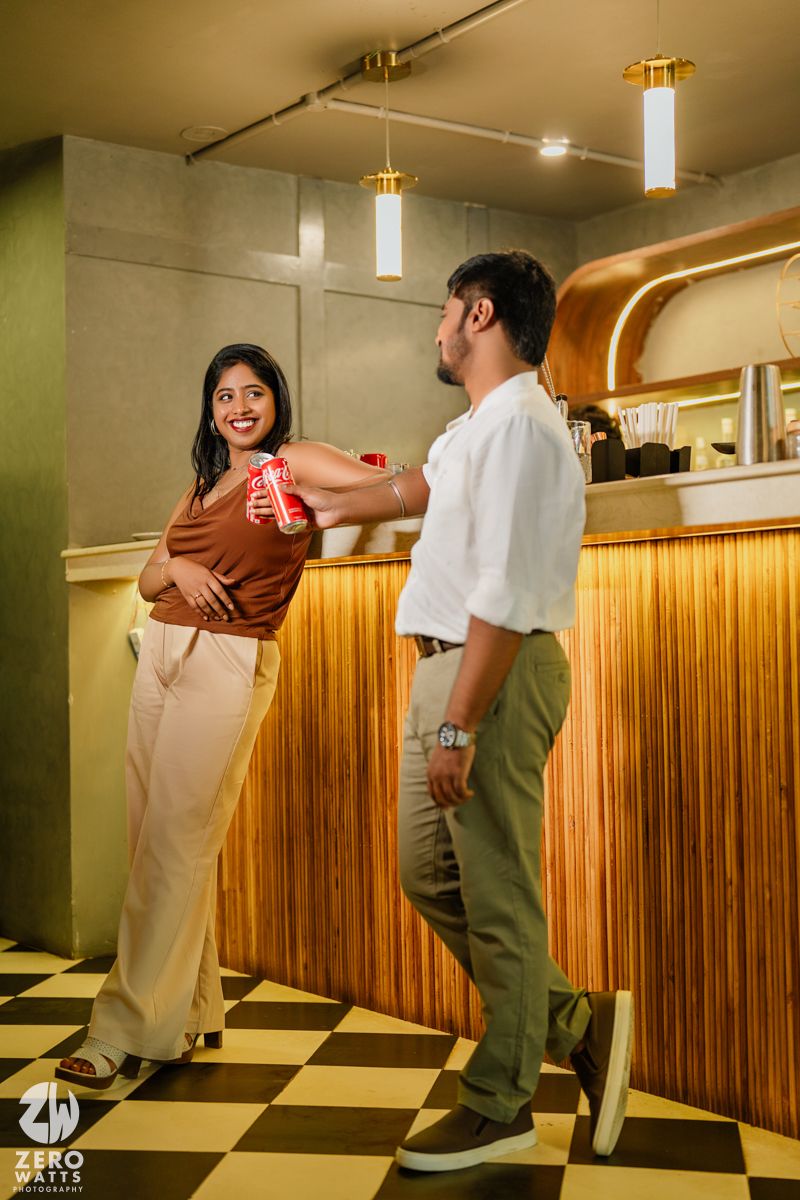 Playful dance sequence of couple in casual attire against wooden wall.