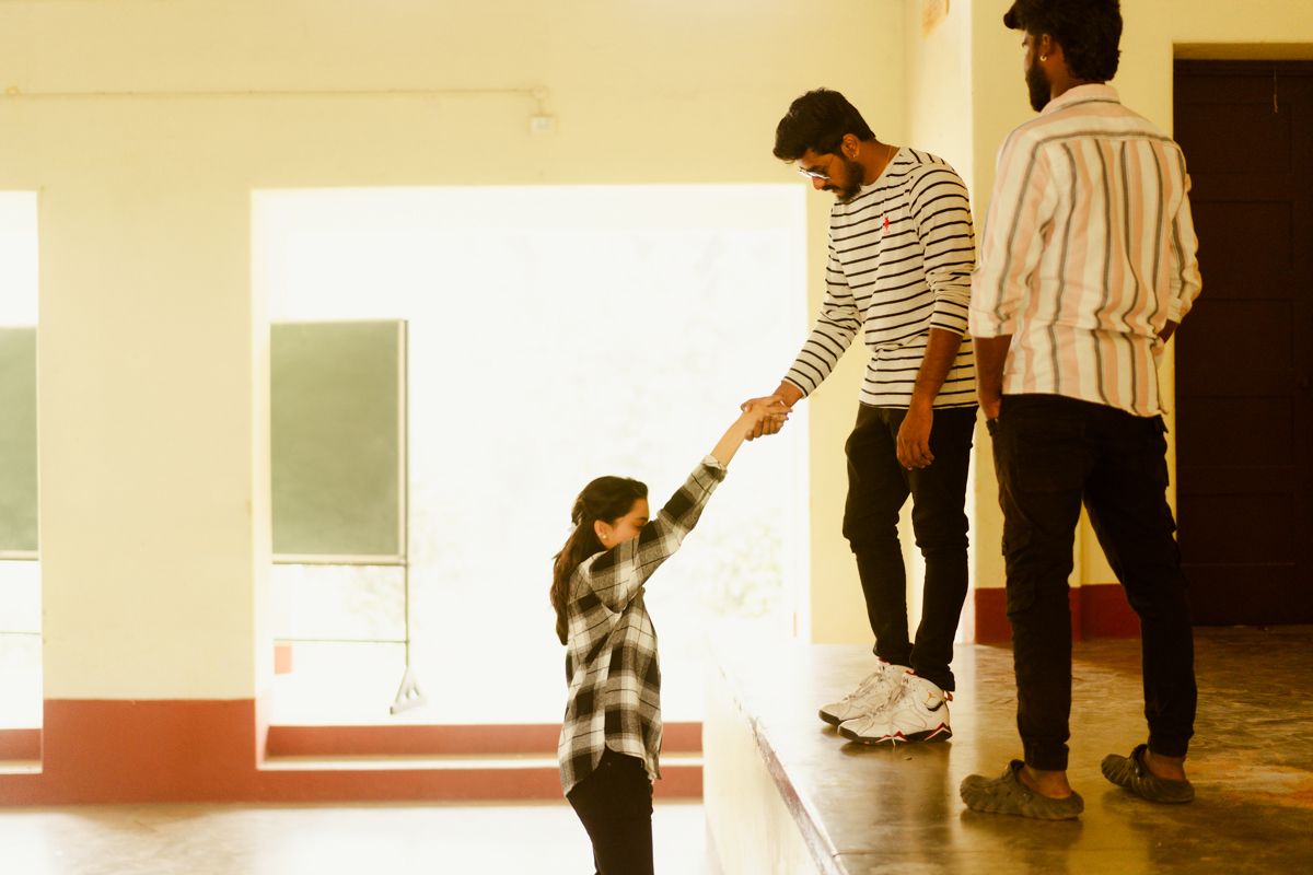 A heartwarming interaction between two figures and a small child in a sunlit indoor space.