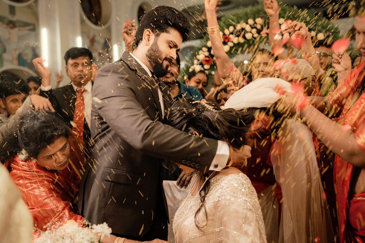 Guests celebrate with confetti during a joyous wedding celebration indoors.