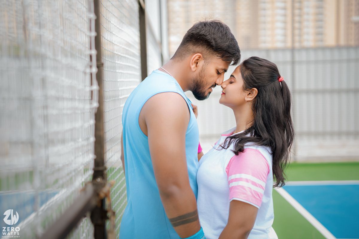 Athletic pair having a romantic moment near white netting.