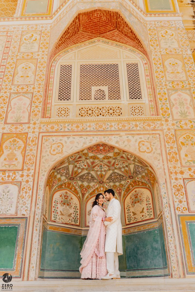 Ornate Mughal architecture with intricate carved archways and geometric patterns in peach and turquoise tones.