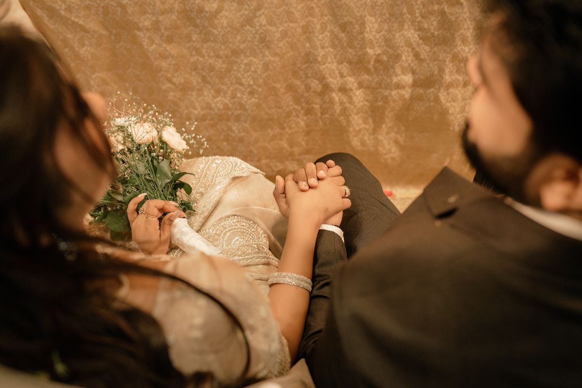 An intimate wedding moment captured from above showing flowers and formal attire.