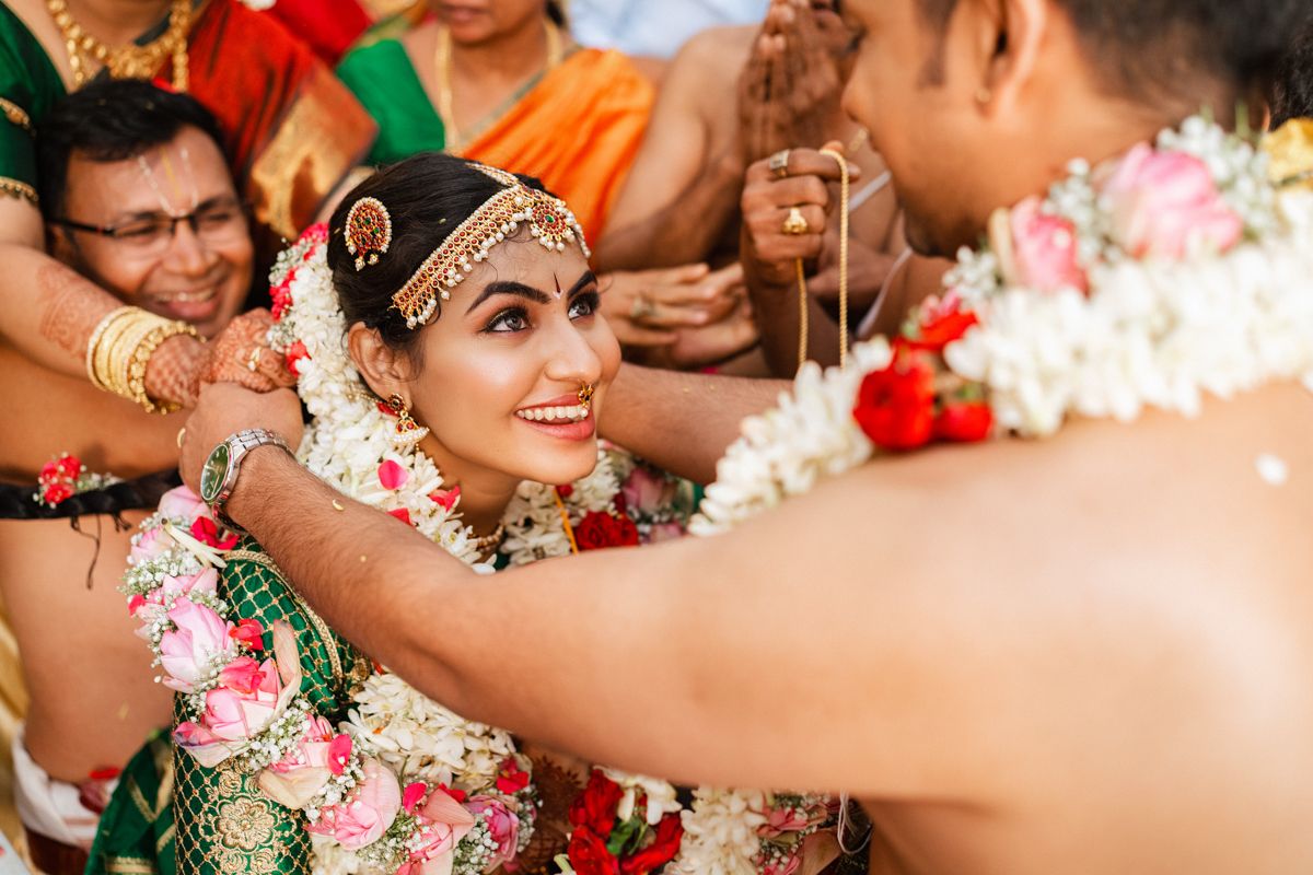 Traditional Indian wedding ceremony moment with flowers and ceremonial decorations.