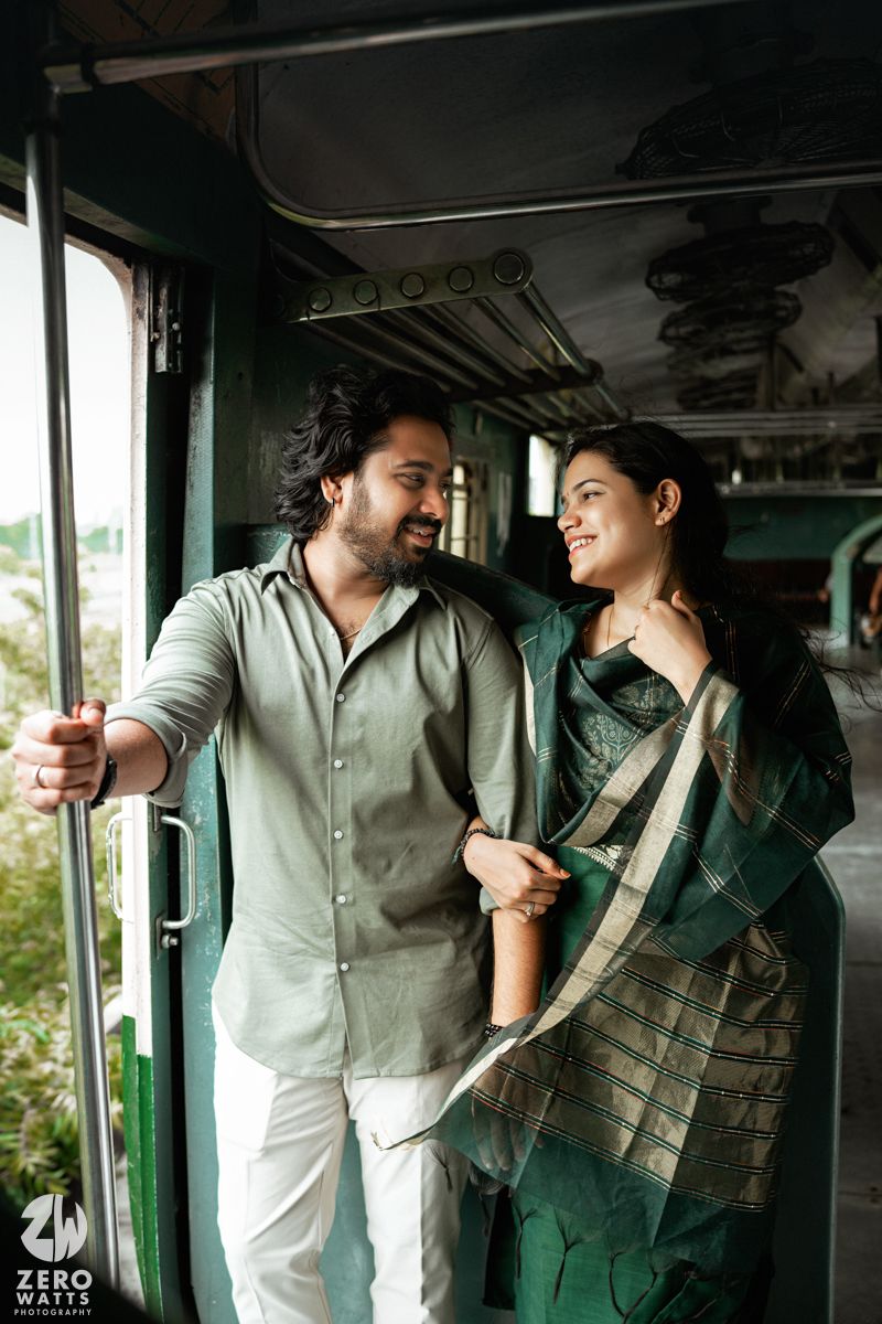 Natural light illuminates tender interactions between couple in green-tinted train compartment.