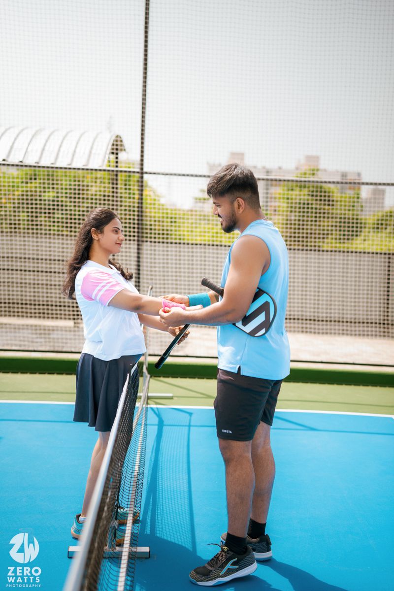 Athletes interacting while standing on a bright blue sports court.