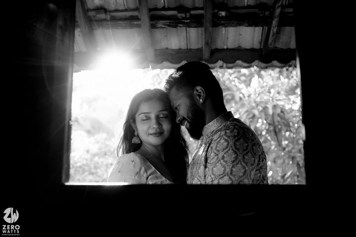 A romantic silhouette of a couple sharing an intimate moment by a sunlit window.
