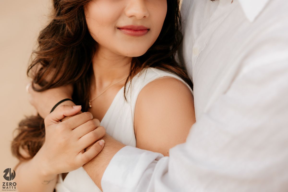 Close up romantic portrait of a couple in white embracing.