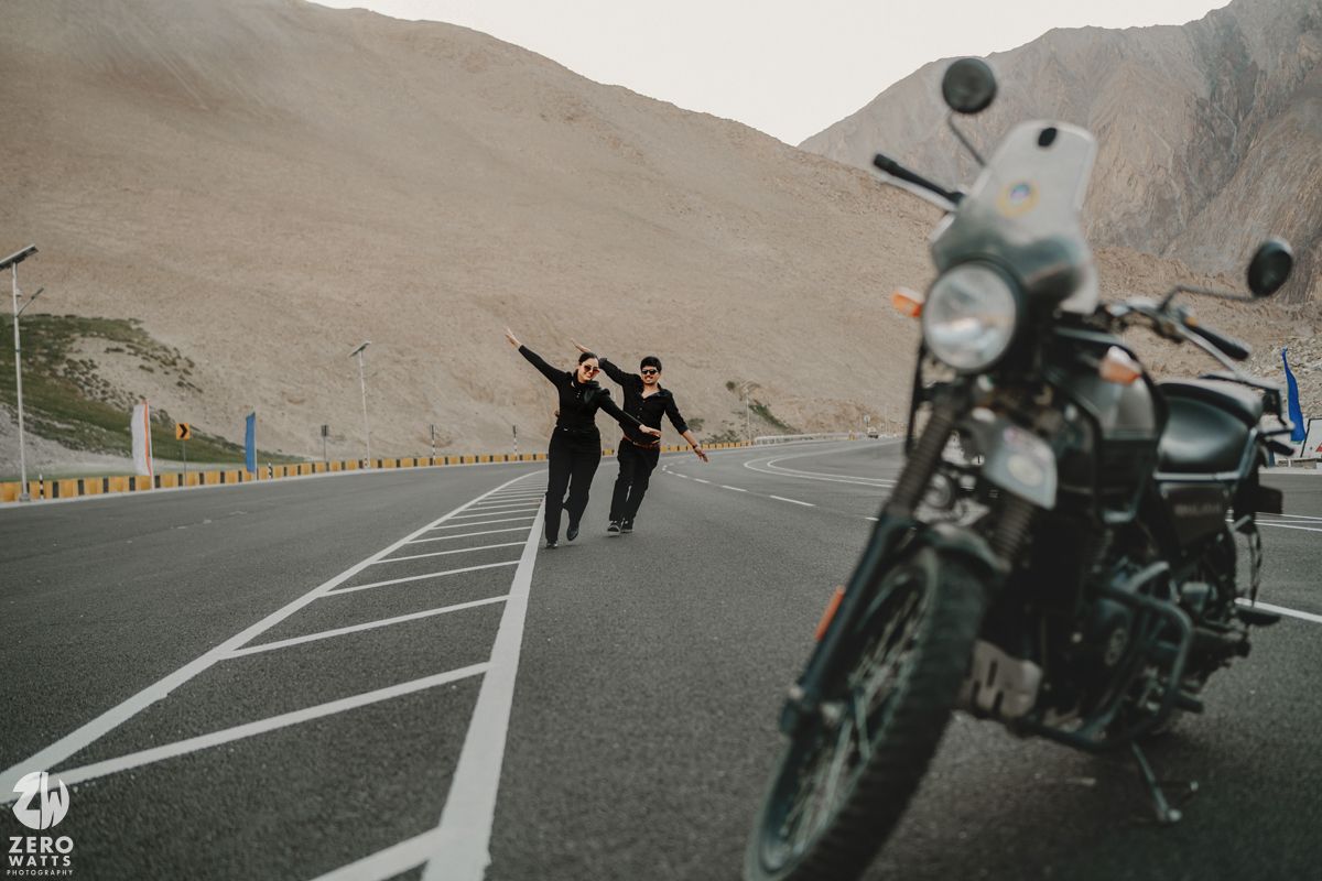 Motorcycle parked on a winding mountain road with scenic desert views.