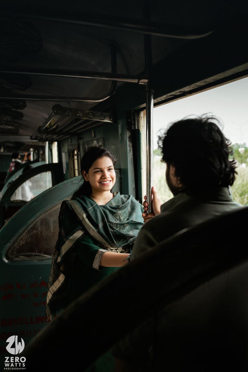 Candid moment captured between two people laughing inside a train compartment.