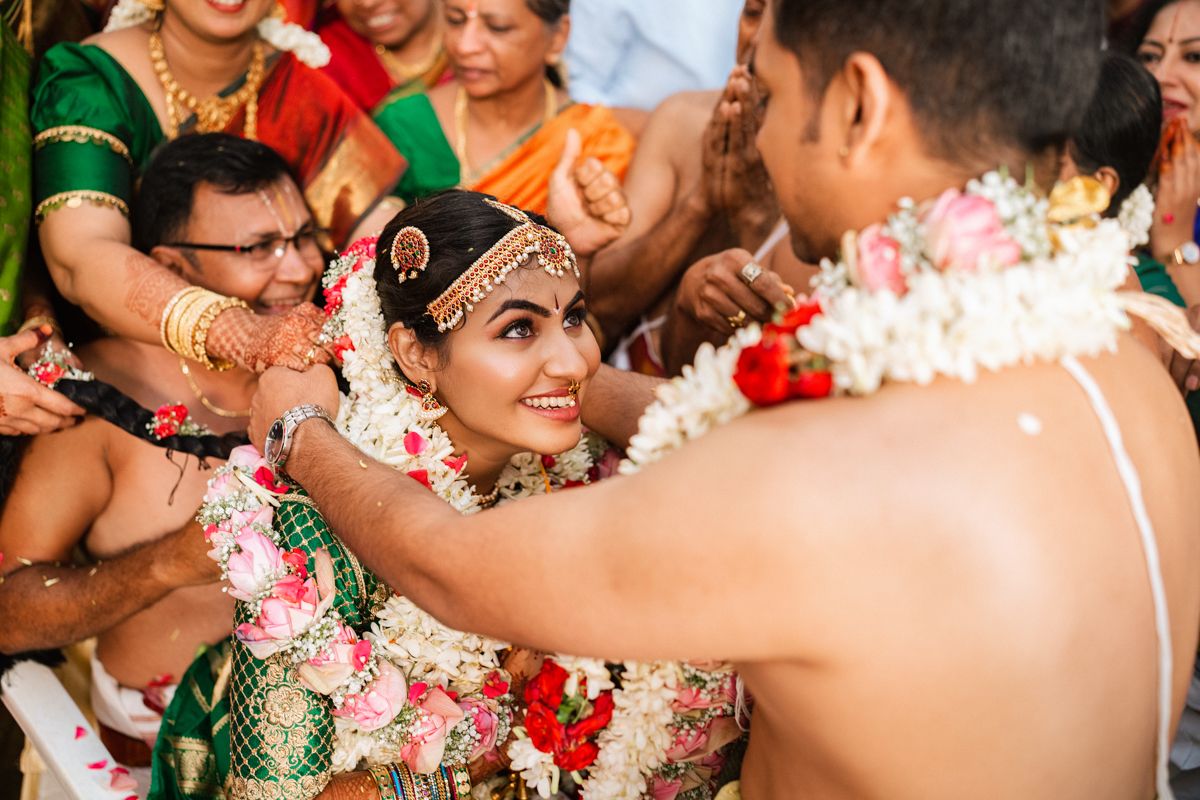 Traditional Indian wedding ceremony with floral decorations and cultural rituals being performed.