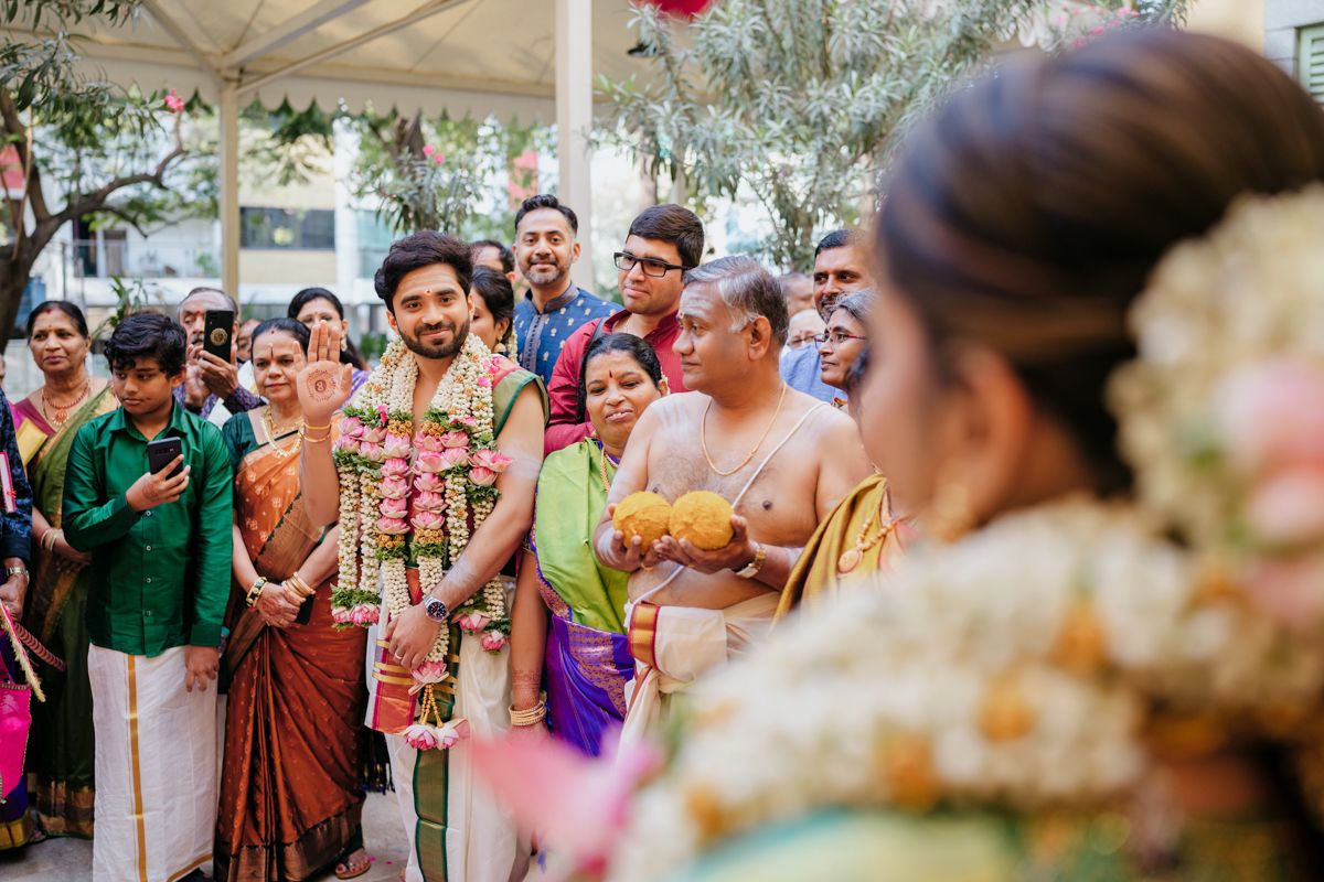 Joyous wedding celebration with guests gathered under a white canopy decorated with flowers.