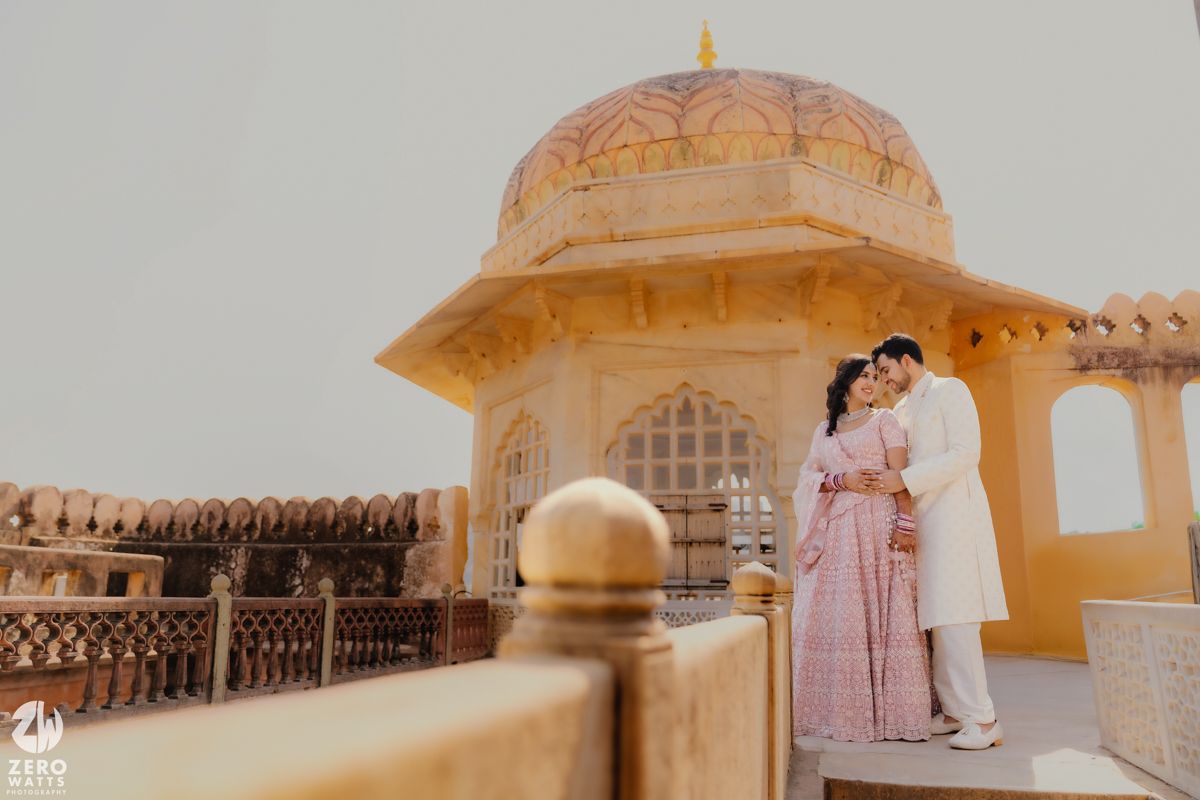 Couple in elegant attire share an intimate moment at a golden domed palace pavilion.