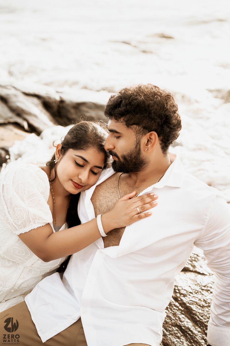 An intimate moment captured between two people during a coastal photoshoot.