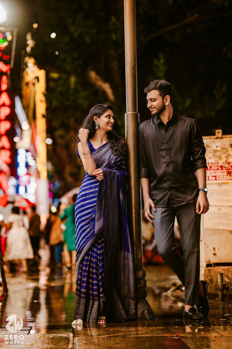 A nighttime street scene with couples walking among illuminated trees and decorative lights.