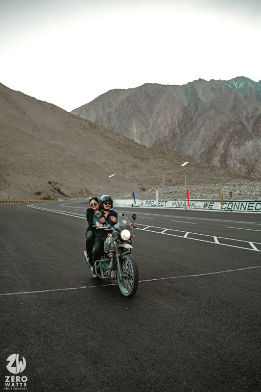 A motorcycle ride along a scenic mountain road with rugged peaks in the backdrop.