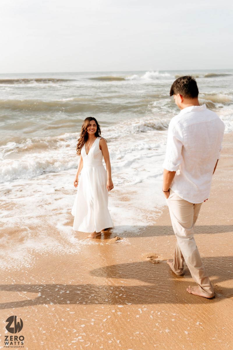 People run and play together through ocean water along a peaceful sandy shoreline.