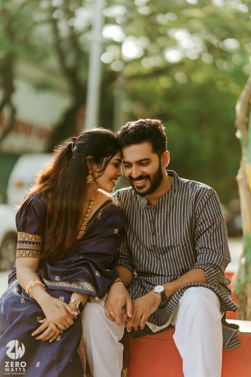 A romantic couple in casual wear sharing candid moments outdoors during a photo session.