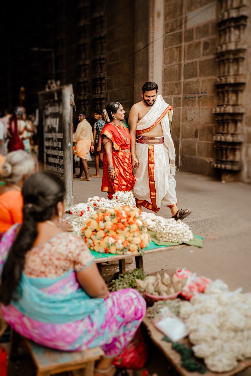 Traditional temple scene with flower vendors selling colorful garlands and offerings.