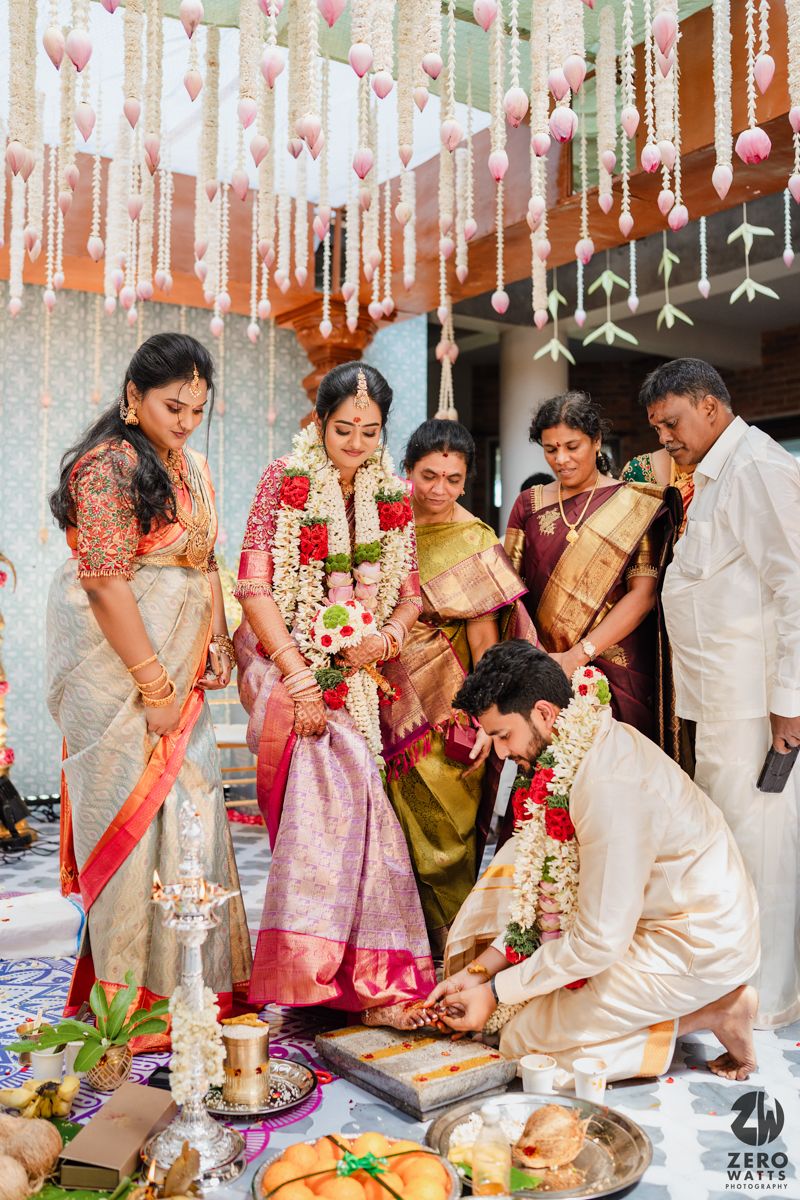 Traditional Indian wedding ceremony with decorative hanging hearts and family performing religious rituals.