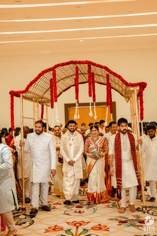 Joyful celebration at Indian wedding with guests in traditional attire during ceremonial rituals.