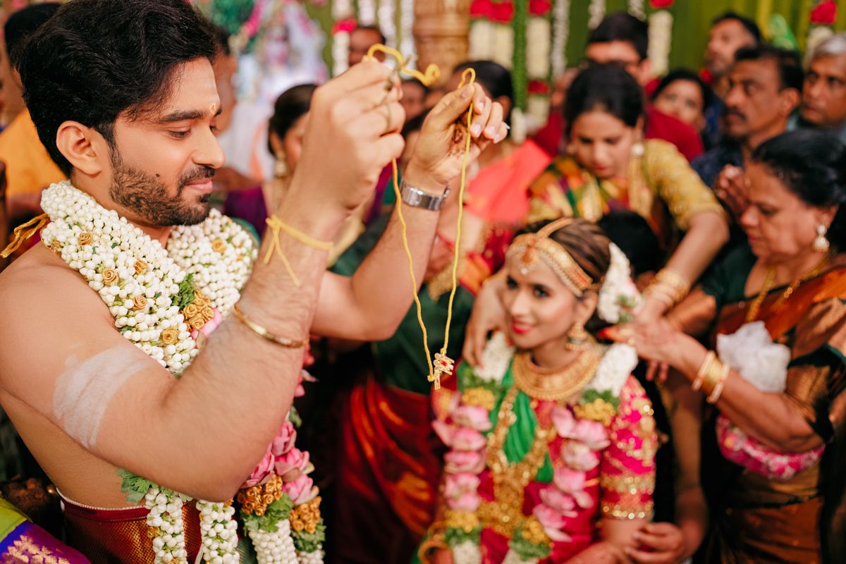 Vibrant traditional wedding ceremony featuring ornate floral garlands and colorful silk attire.