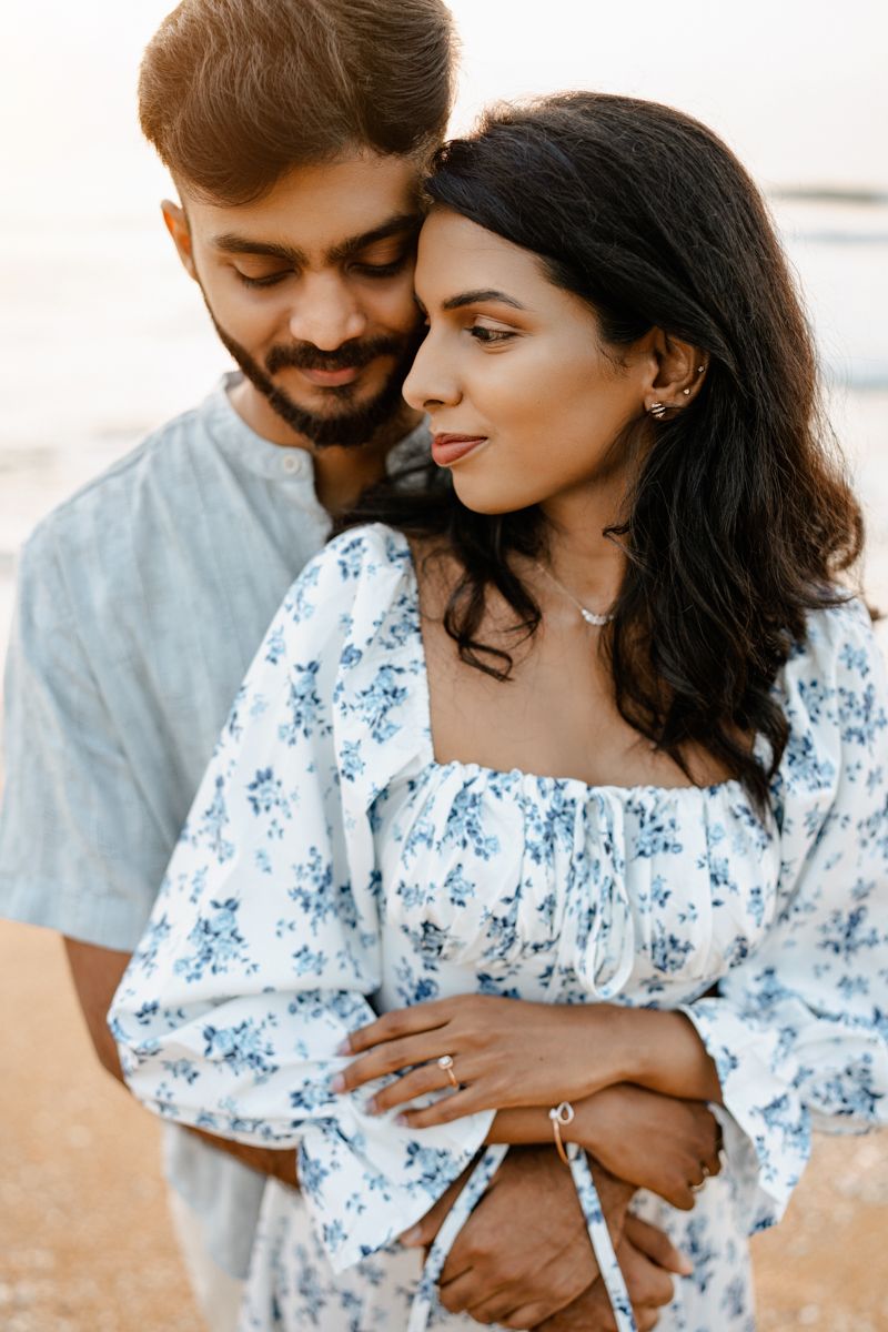 A romantic sunset portrait featuring warm embraces and delicate floral fashion details.